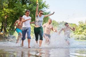 grupo de amigos felices divirtiéndose en el río foto