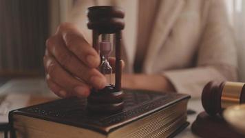 Justice and law concept.Male judge in a courtroom with the gavel, working with, computer and docking keyboard, eyeglasses, on table in morning light video