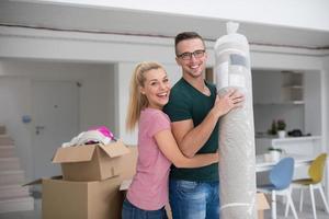 couple carrying a carpet moving in to new home photo