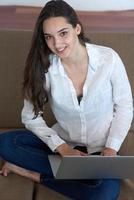 relaxed young woman at home working on laptop computer photo