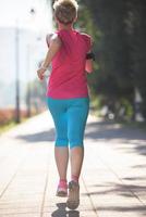 sporty woman running  on sidewalk photo