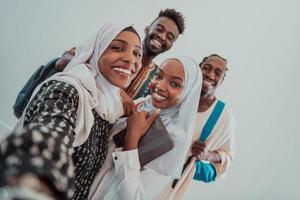 A group of multiethnic students take a selfie with a smartphone on a white background. Selective focus photo