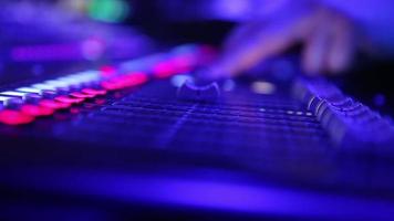 elettrico macchina su tavolo per Lavorando di suono progettista o club dj a festa nel discoteca nel neon blu e viola illuminazione.occupazione per moderno stile di vita video