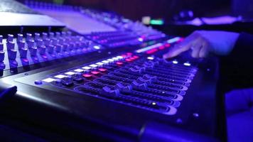 elettrico macchina su tavolo per Lavorando di suono progettista o club dj a festa nel discoteca nel neon blu e viola illuminazione.occupazione per moderno stile di vita