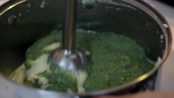 batido verde saludable con aguacate mezclado en una licuadora. primer plano del proceso de cocción video
