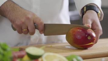 Chef cuts mango on wooden board video
