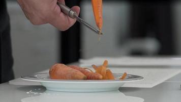 maschio mani peeling biologico carote. avvicinamento Visualizza di mani di maschio cucinare peeling video