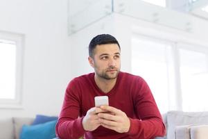 young man using a mobile phone  at home photo