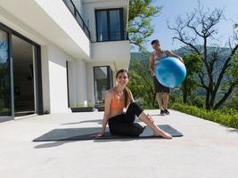 woman and personal trainer doing exercise with pilates ball photo