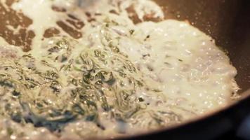 The chef pours cream on the spinach and interferes with a spatula. video