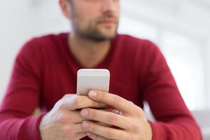 young man using a mobile phone  at home photo