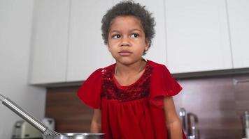 Young girl in red dress looks at camera while chewing and smiling video