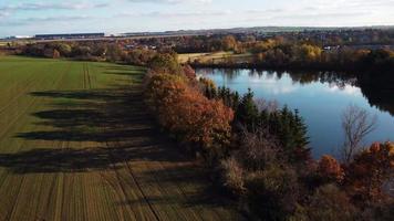 Aerial view of autumn landscape with lake, trees and field video