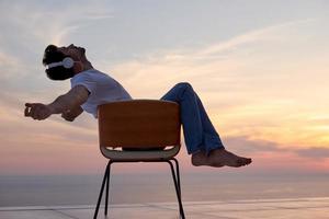 relaxed young man at home on balcony photo