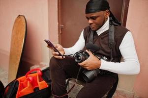 joven camarógrafo afroamericano profesional con cámara profesional con equipo profesional. camarógrafo afro con duraq negro haciendo videos. foto