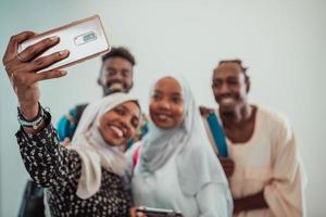 A group of multiethnic students take a selfie with a smartphone on a white background. Selective focus photo