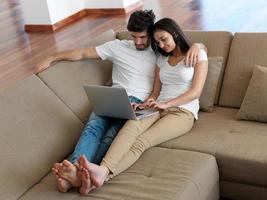 relaxed young couple working on laptop computer at home photo