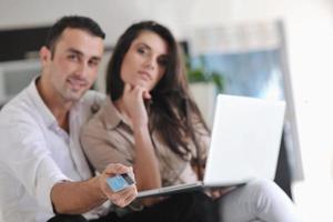 joyful couple relax and work on laptop computer at modern home photo