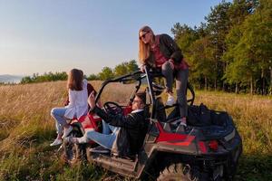 group young happy people enjoying beautiful sunny day while driving a off road buggy car photo