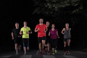 equipo de corredores en el entrenamiento nocturno foto