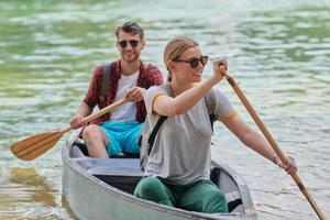 friends are canoeing in a wild river photo