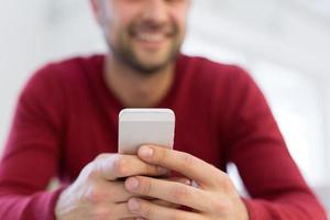 young man using a mobile phone  at home photo