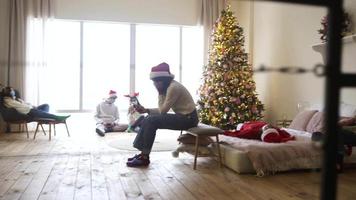 Urlaubsparty mit Leuten in Weihnachtsmützen, die müde mit Telefonen sitzen oder sich hinlegen