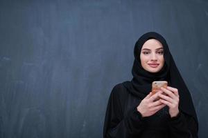 young modern muslim business woman using smartphone photo