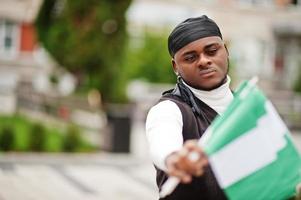 Young african american man hold nigerian flags in hands. photo