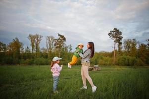 madre con niños divirtiéndose juntos en el prado. foto