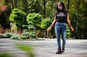 Fashionable african american woman, wear hand made face mask posing outdoor. New normal life. photo