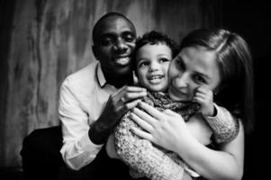 Happy multiethnic family with boy kid spend time at restaurant. Relationships of african man and white european woman. photo