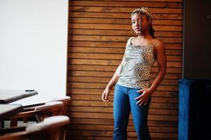 Lovely african american woman with dreadlocks in leopard outfit at cafe. Beautiful cool fashionable black young girl indoor. photo