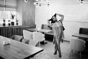 Young stylish african american woman pose at cafe. photo