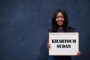 African woman hold white board with Khartoum Sudan inscription. Most populous city in Africa concept. photo