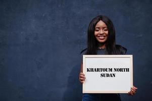 African woman hold white board with Khartoum North Sudan inscription. Most populous city in Africa concept. photo