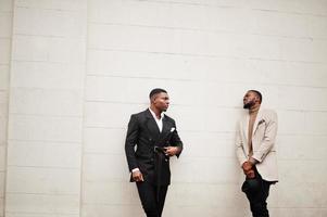 Two fashion black men. Fashionable portrait of african american male models. Wear suit, coat and hat. photo