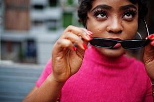 Urban young african american woman in pink top. Afro fashion chic women with ring piercing in nose. photo