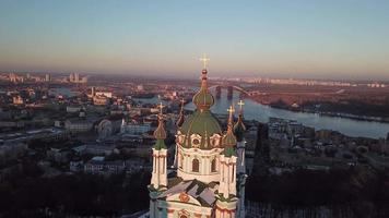Aerial view of St Andrews Church with orange trees in fall and city Kyiv, Ukraine on horizon video