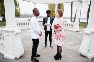 ceremonia de compromiso de boda con el pastor. feliz pareja multiétnica en la historia de amor. relaciones de hombre africano y mujer europea blanca. foto