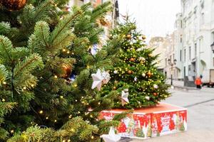 close up of christmas trees decoration with toys and garlands. City festive decor during winter holidays photo