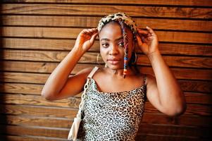 Lovely african american woman with dreadlocks in leopard outfit at cafe. Beautiful cool fashionable black young girl indoor. photo