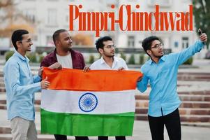 Pimpri-Chinchwad city inscription. Group of four indian male friends with India flag making selfie on mobile phone. Largest India cities concept. photo