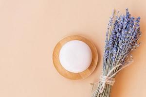 Handmade lavender Soap. bar of natural soap of ball shape with dried lavender flowers on a wooden plate. Organic cosmetics for skin care and spa photo