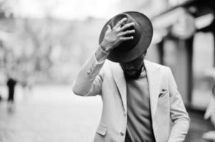 Stylish african american man wear beige jacket and black hat pose at street. photo