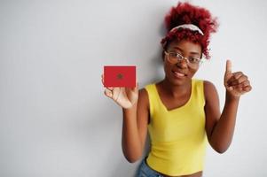 African woman with afro hair, wear yellow singlet and eyeglasses, hold Morocco flag isolated on white background, show thumb up. photo