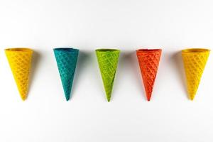 Set of various bright multicolored ice-cream waffle cones on white background . photo