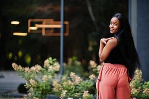 mujer afroamericana de moda en pantalones de melocotón y blusa negra posan al aire libre. foto