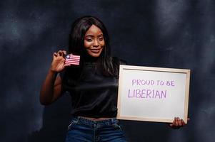 Proud to be liberian. Fashionable african woman hold board with Liberia flag. photo