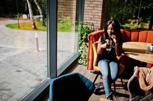 Fashionable african american woman at restaurant drink lemonade. photo